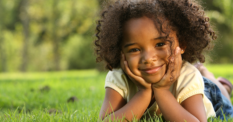 A little girl lying on the grass