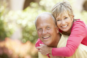 A mature couple is hugging and smiling